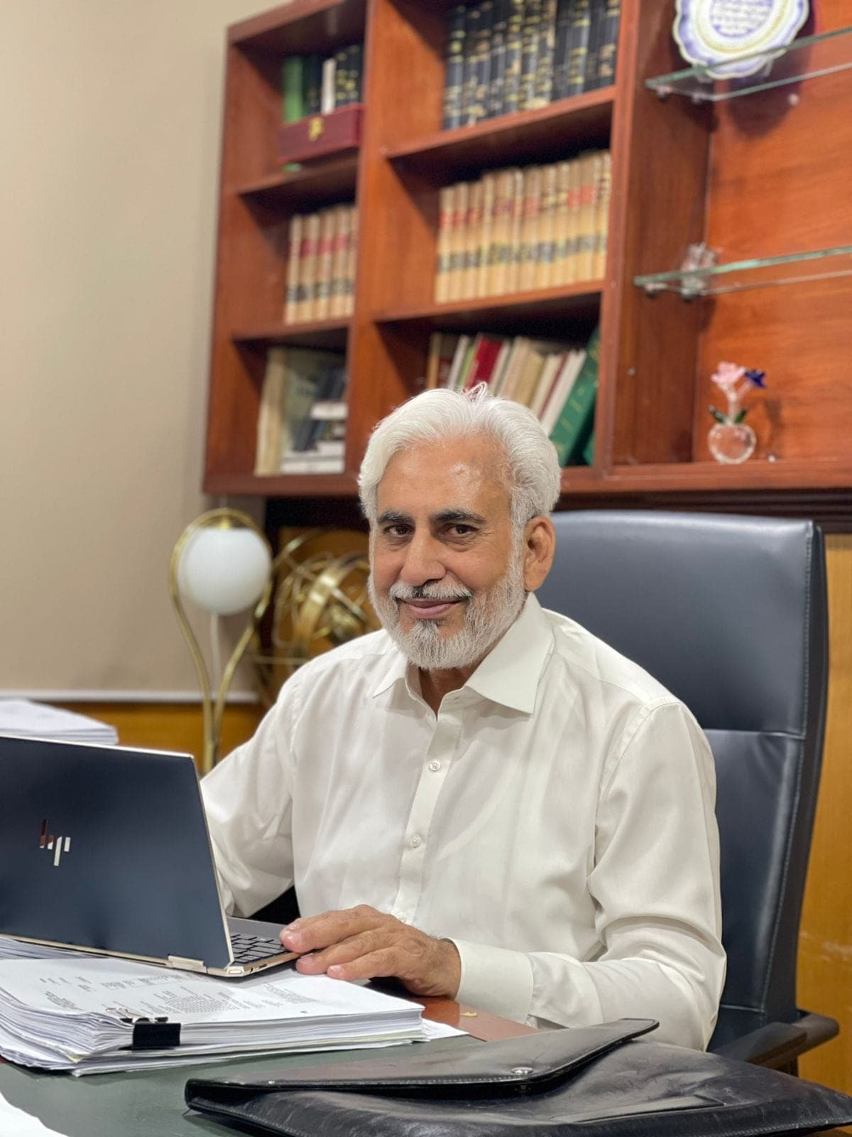 Muhammad Siddique, Founder & CEO, seated at his desk in front of a bookcase of law reports